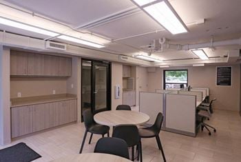 Resident business center with tables, seating, and window